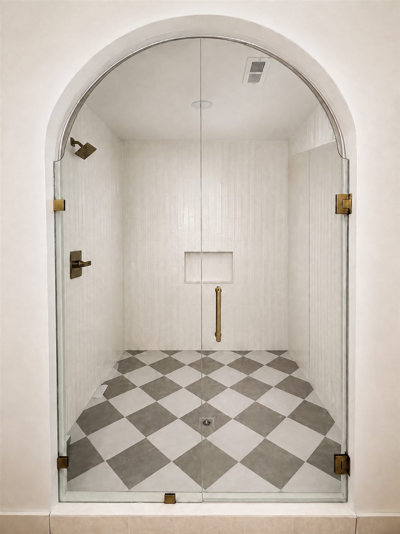 Frameless shower glass fitted to an arched opening