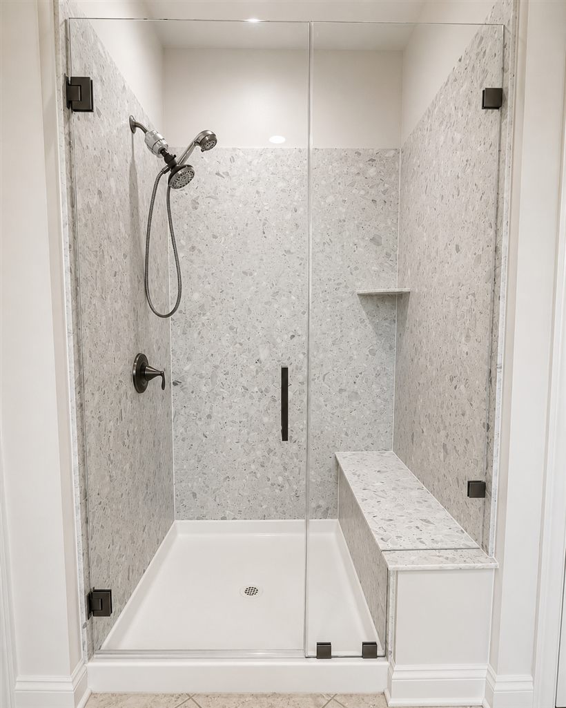 Frameless shower with fixed panel, door, and built-in bench